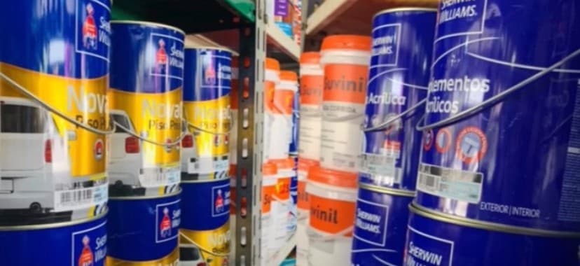 Prateleira da loja cheia de latas de tinta Sherwin-Williams e Suvinil